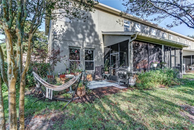 8419 Chamberlain Pl, Oviedo, FL 32765 - back of house with a sunroom, a lawn, and stucco siding