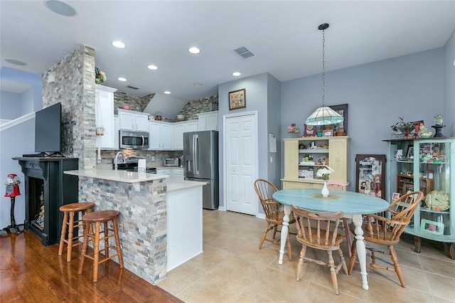 8419 Chamberlain Pl, Oviedo, FL 32765 - kitchen featuring a breakfast bar, a peninsula, light countertops, visible vents, and stainless steel appliances
