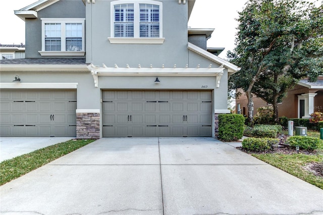 8419 Chamberlain Pl, Oviedo, FL 32765 - view of front of home with concrete driveway, stucco siding, stone siding, and an attached garage