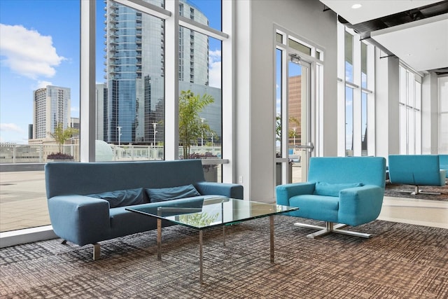 common area featuring a high ceiling, a wall of windows, and a city view