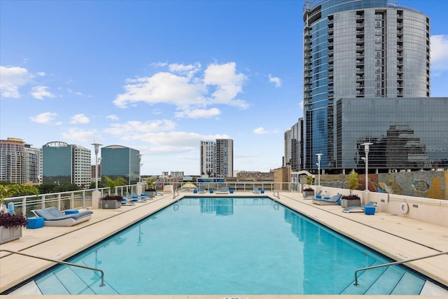 community pool featuring a view of city and fence