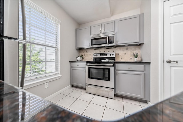 kitchen with appliances with stainless steel finishes, light tile patterned flooring, and gray cabinetry