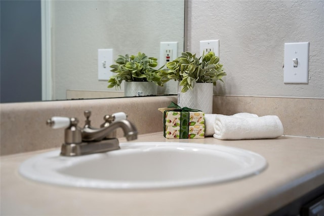 room details featuring vanity and a textured wall
