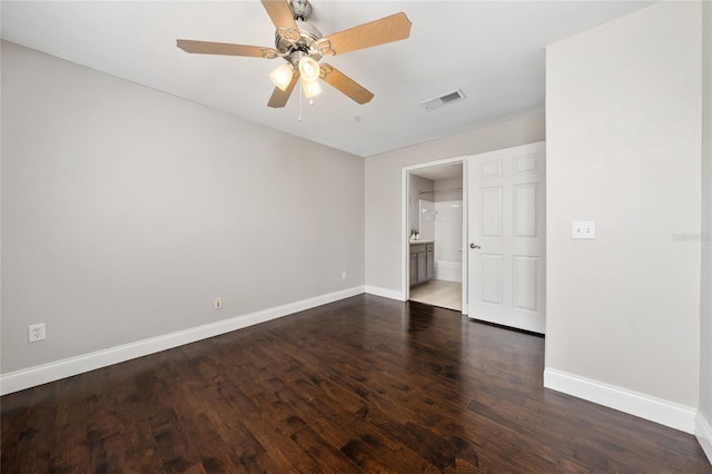 spare room featuring visible vents, baseboards, ceiling fan, and dark wood finished floors
