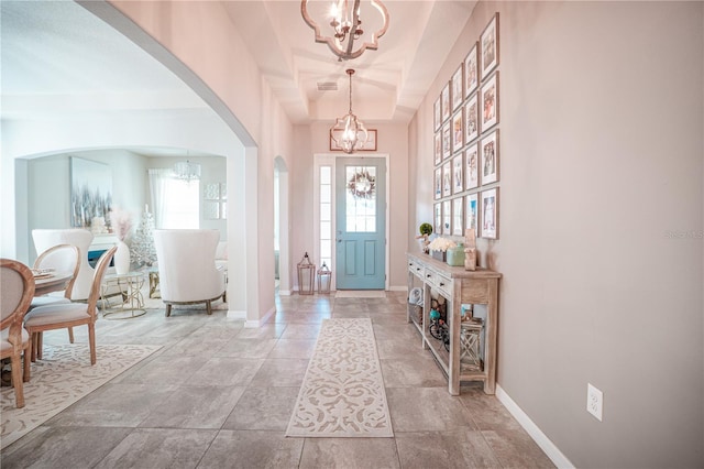 3041 Cardillino Way, Kissimmee, FL 34741 - foyer entrance with a chandelier, arched walkways, baseboards, and a tray ceiling
