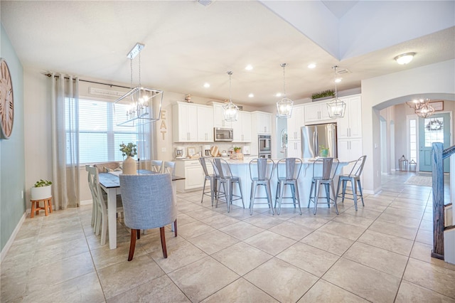 3041 Cardillino Way, Kissimmee, FL 34741 - dining room with a chandelier, arched walkways, light tile patterned floors, and baseboards