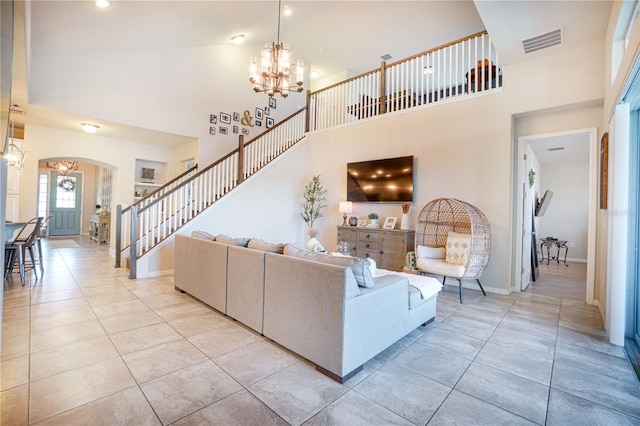 3041 Cardillino Way, Kissimmee, FL 34741 - living room with arched walkways, visible vents, an inviting chandelier, and stairs