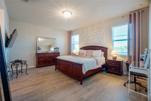 3041 Cardillino Way, Kissimmee, FL 34741 - bedroom featuring a textured ceiling, light wood finished floors, and baseboards
