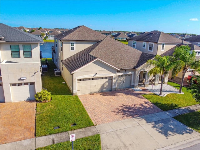 3041 Cardillino Way, Kissimmee, FL 34741 - traditional home featuring a garage, a residential view, stucco siding, and decorative driveway