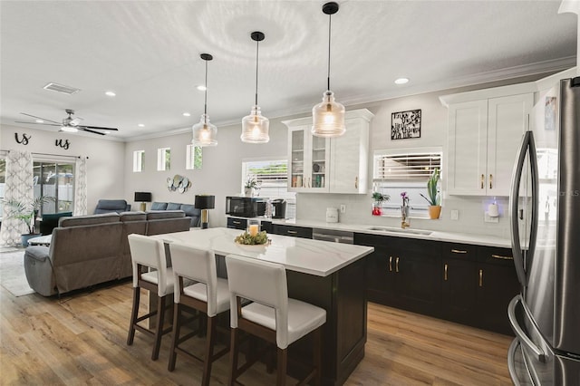 kitchen with dark cabinetry, appliances with stainless steel finishes, white cabinetry, and a sink