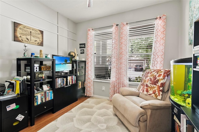 living area featuring baseboards and wood finished floors