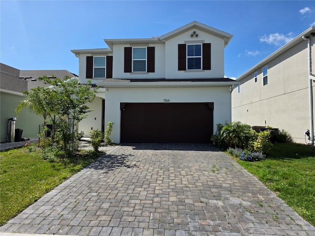 1764 Stamen Dr, Kissimmee, FL 34744 - view of front facade with stucco siding, decorative driveway, and an attached garage