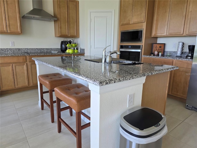 1764 Stamen Dr, Kissimmee, FL 34744 - kitchen with dark stone counters, wall chimney exhaust hood, a kitchen breakfast bar, light tile patterned flooring, and stainless steel appliances