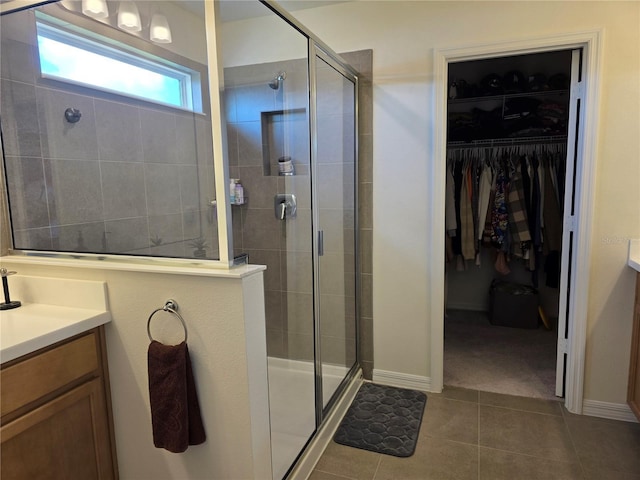 1764 Stamen Dr, Kissimmee, FL 34744 - bathroom featuring tile patterned flooring, a tile shower, a walk in closet, and vanity
