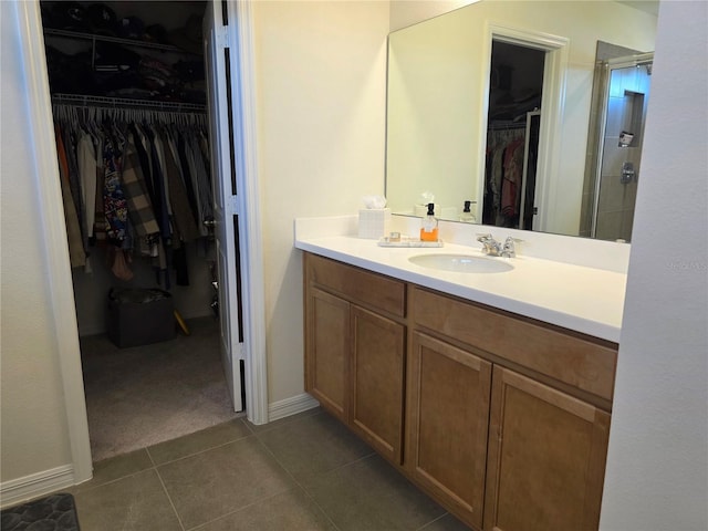 1764 Stamen Dr, Kissimmee, FL 34744 - full bath featuring tile patterned flooring, a spacious closet, vanity, and a shower with door