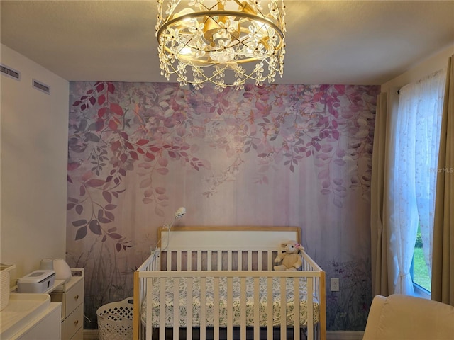 1764 Stamen Dr, Kissimmee, FL 34744 - bedroom featuring a crib, visible vents, a notable chandelier, and wallpapered walls