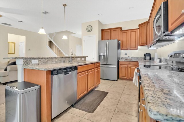 987 Alston Bay Blvd, Apopka, FL 32703 - kitchen with appliances with stainless steel finishes, an island with sink, light tile patterned floors, pendant lighting, and light stone counters