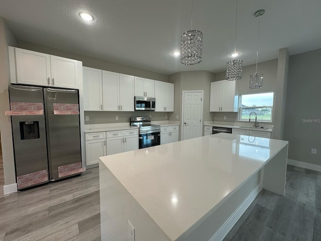 kitchen featuring light wood-style flooring, light countertops, white cabinets, and stainless steel appliances