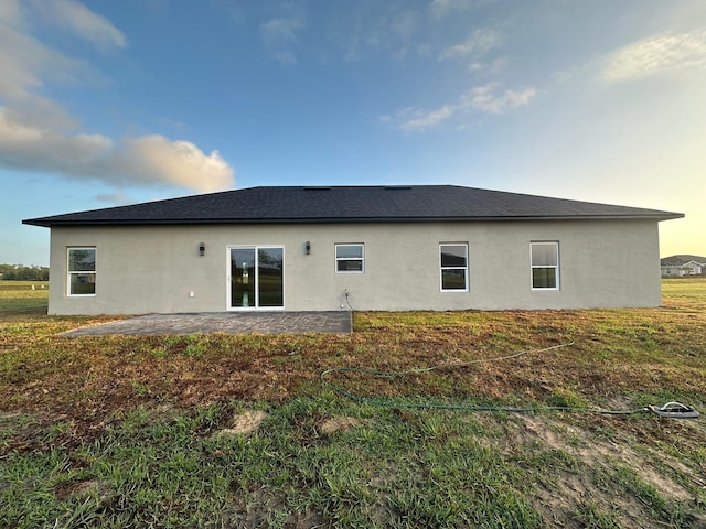 rear view of property featuring a patio and stucco siding