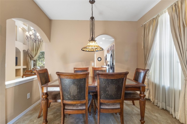 9244 Pecky Cypress Way, Orlando, FL 32836 - dining area featuring light colored carpet, arched walkways, and baseboards