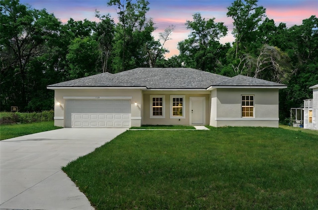 single story home featuring a garage, concrete driveway, a yard, and stucco siding
