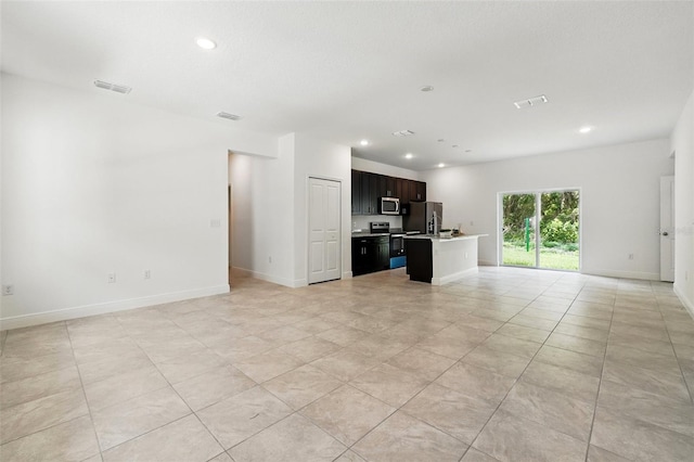 unfurnished living room featuring recessed lighting, baseboards, and light tile patterned floors