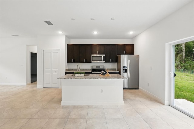 kitchen with stainless steel appliances, a sink, a kitchen island with sink, light tile patterned floors, and recessed lighting