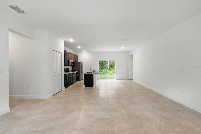 unfurnished living room with baseboards, a sink, recessed lighting, and light tile patterned floors