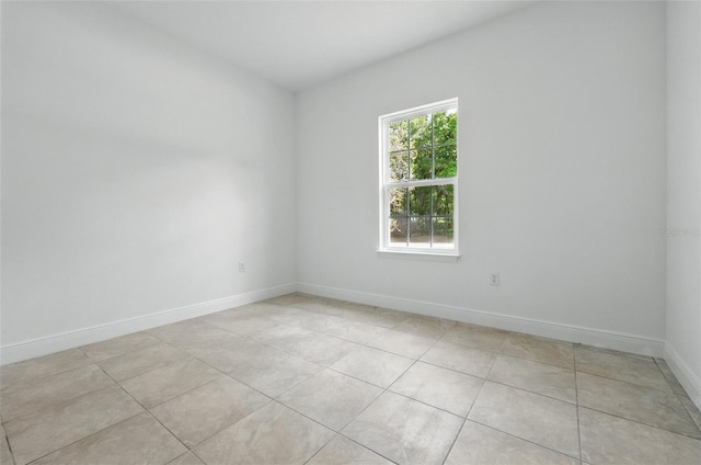 empty room featuring light tile patterned floors and baseboards