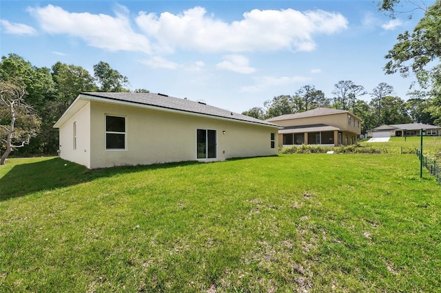 back of property featuring stucco siding and a lawn