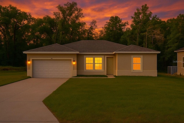 view of front facade featuring a garage, stucco siding, driveway, and a yard
