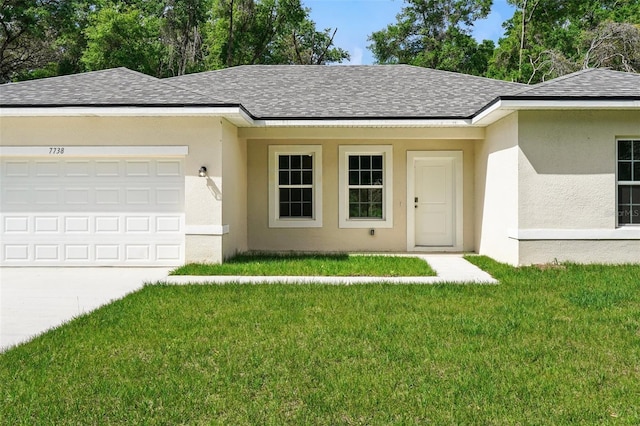 ranch-style home with roof with shingles, stucco siding, a front lawn, an attached garage, and concrete driveway