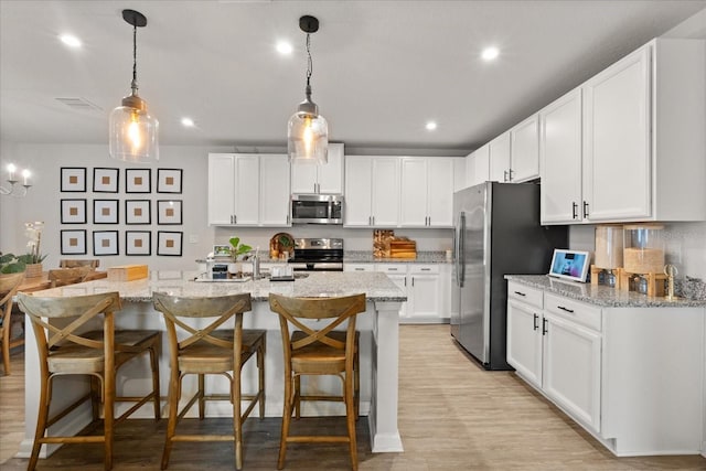 4301 Creek Bank Dr, Kissimmee, FL 34744 - kitchen with a breakfast bar area, white cabinetry, light stone counters, and stainless steel appliances