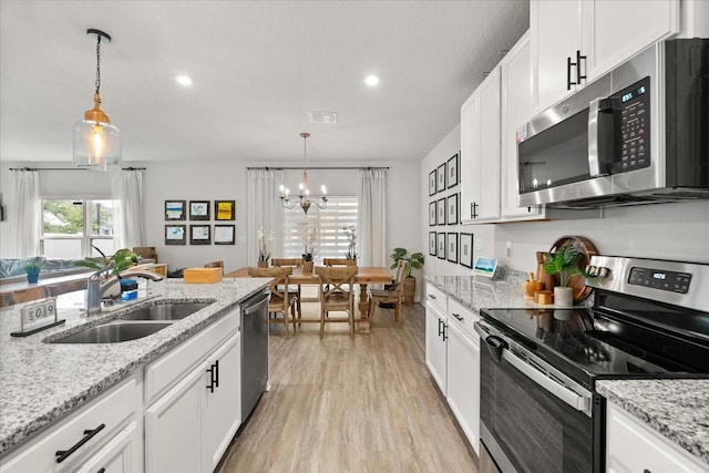 4301 Creek Bank Dr, Kissimmee, FL 34744 - kitchen featuring a chandelier, white cabinets, visible vents, stainless steel appliances, and a sink