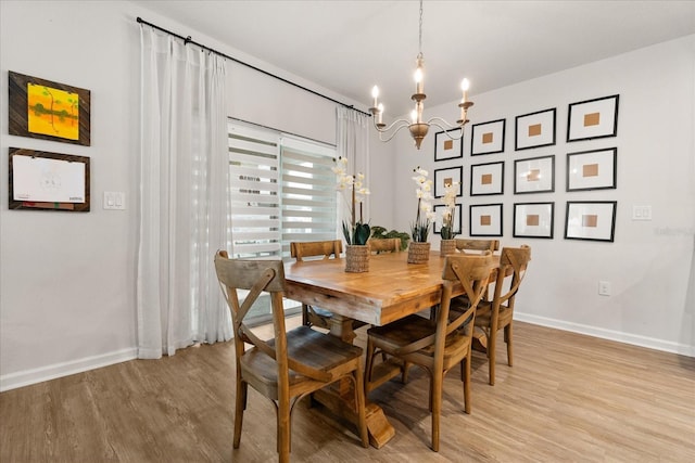 4301 Creek Bank Dr, Kissimmee, FL 34744 - dining room featuring baseboards, light wood-type flooring, and a notable chandelier