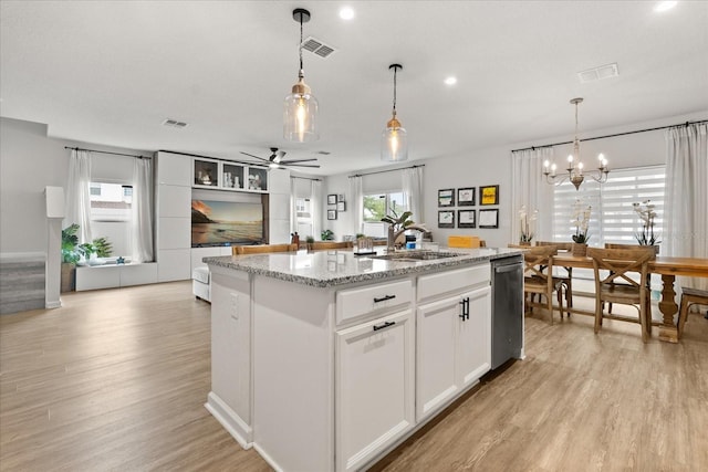 4301 Creek Bank Dr, Kissimmee, FL 34744 - kitchen with dishwasher, a sink, an island with sink, light wood-style floors, and ceiling fan with notable chandelier