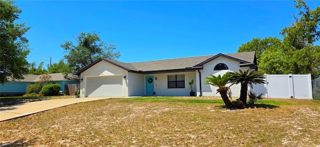ranch-style house with fence, concrete driveway, a front yard, and a garage