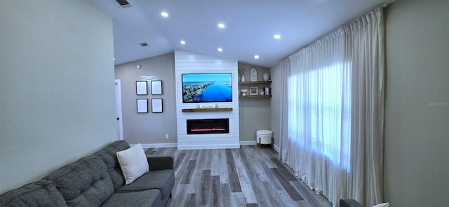 living room with lofted ceiling, wood finished floors, a fireplace, and recessed lighting