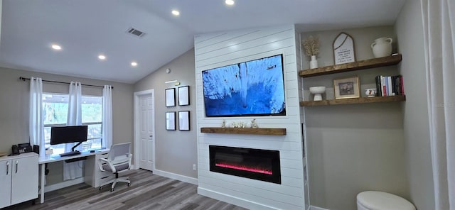 home office featuring lofted ceiling, wood finished floors, visible vents, and recessed lighting