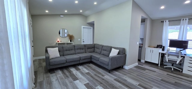 living room featuring recessed lighting, lofted ceiling, and light wood-style flooring