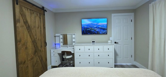 bedroom featuring a barn door, wood finished floors, baseboards, and ornamental molding