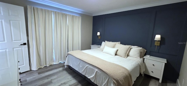 bedroom with crown molding and wood finished floors
