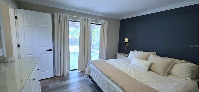 bedroom with wood finished floors, crown molding, and access to outside