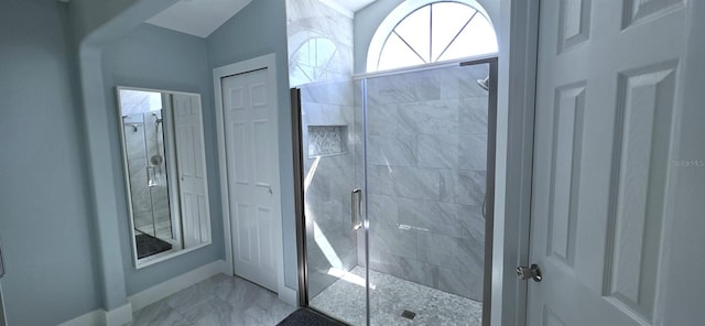 bathroom with baseboards, marble finish floor, and a shower stall