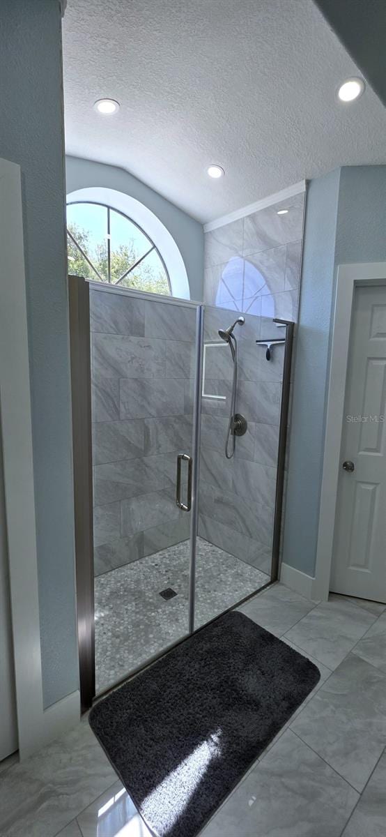 full bath with recessed lighting, a shower stall, a textured ceiling, and marble finish floor