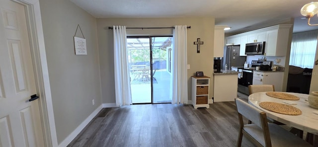 dining room featuring baseboards and dark wood-style flooring