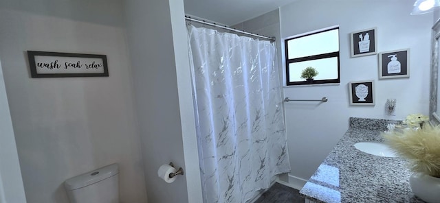full bath featuring toilet, vanity, and curtained shower