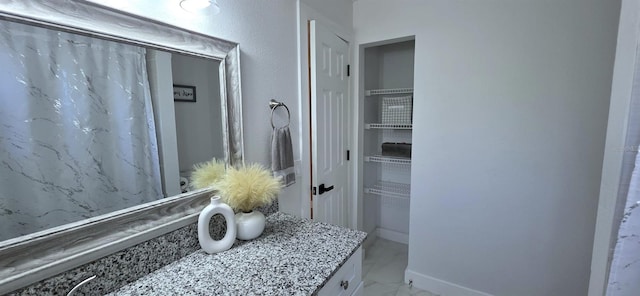 bathroom featuring marble finish floor and vanity