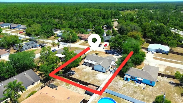 drone / aerial view featuring a residential view and a wooded view