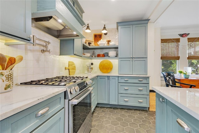 kitchen featuring tasteful backsplash, stainless steel range with gas stovetop, ornamental molding, wall chimney exhaust hood, and dark tile patterned flooring
